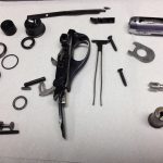 Completely disassembled trigger assembly for a Remington 870 shotgun